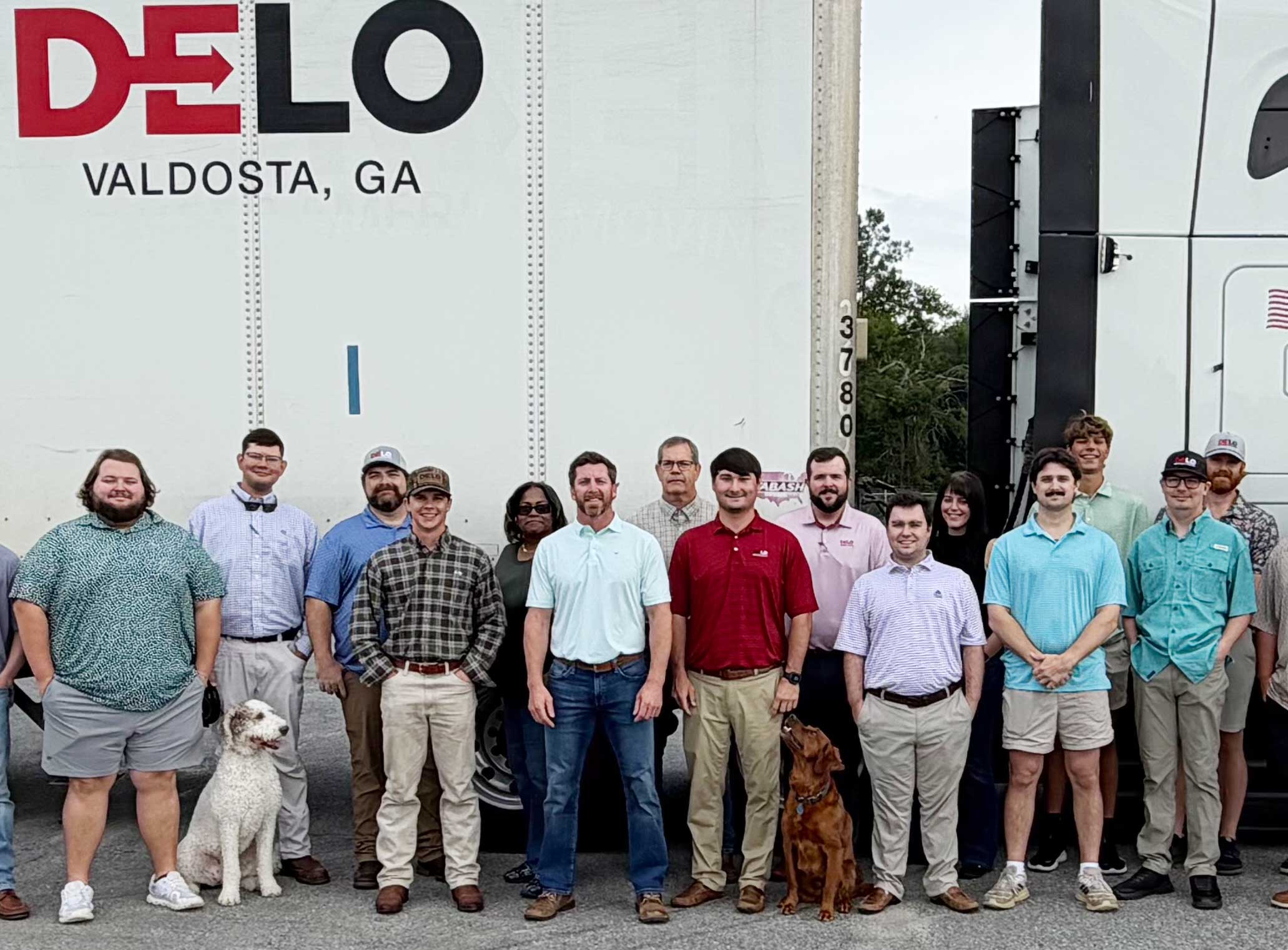 Desirable Logistics Company Photo - Todd Parramore and Employees next to a DeLo truck and trailer